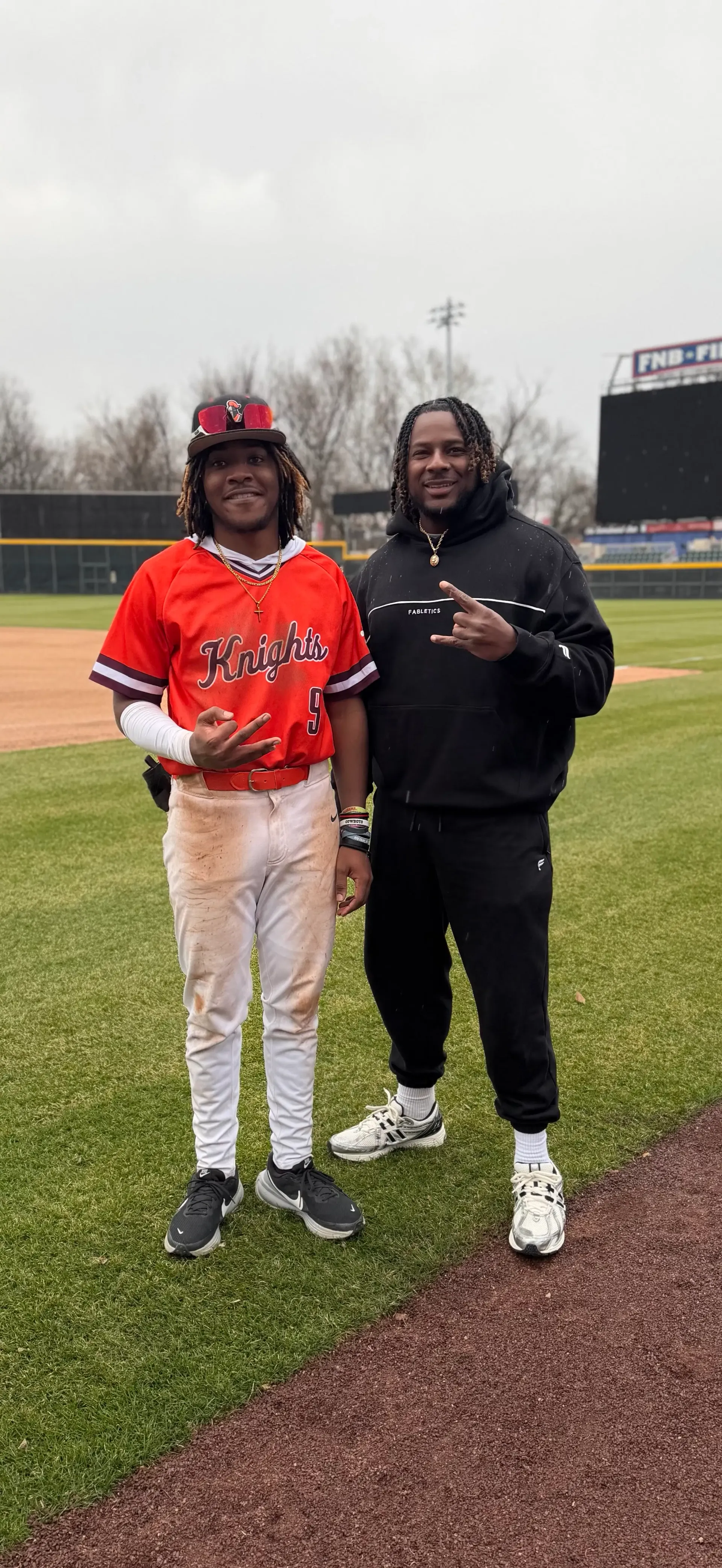 Coach Darnell Newman with his son on a baseball field